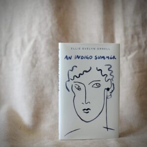 A hardback book with a white cover. Showing a blue ink line drawing of a face. Shown against a pale pink fabric backdrop.