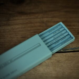 A light blue slide-out box containing six drawing pencils which are embossed with key words relating to the Visual Arts: 