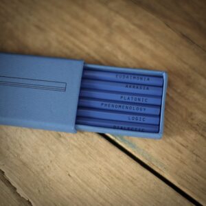 A blue slide-out box, containing six pencils the philosophical keywords: 