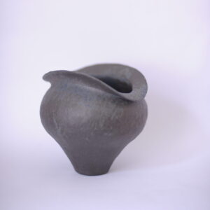 small, bulbous black vase against a white background 