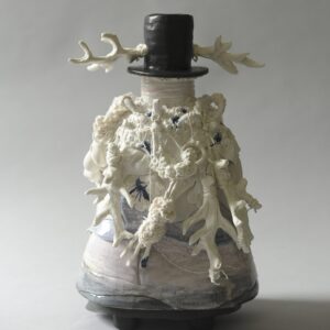 Porcelain sculpture depicting a welsh figure with traditional Welsh hat with antlers on each side. 